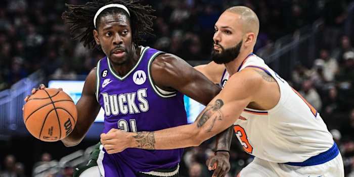 Holiday (L) guarded by Knicks defender Evan Fournier during a 2022 game